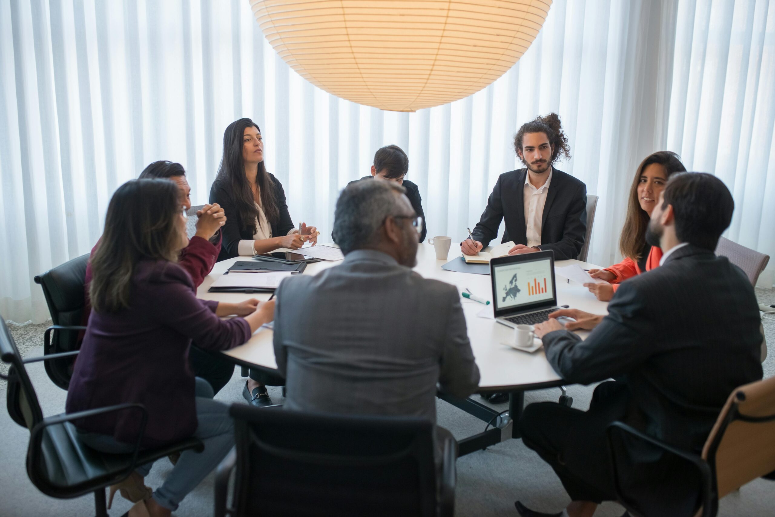 A diverse group of professionals discussing business strategy in a modern office setting.